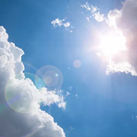 A sunny day with a few clouds.