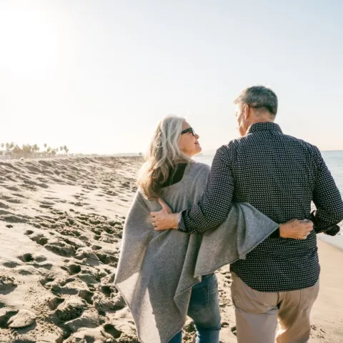 Older couple walking on beach