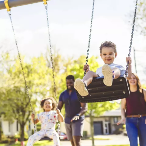 Playtime Moments. family With child Swinging Having Fun on the Playground Outside, 