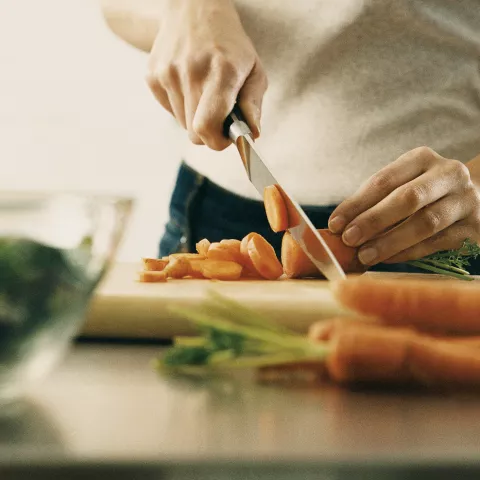 person cutting carrots