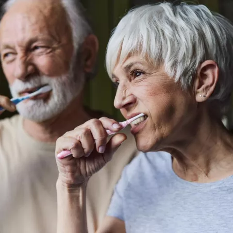 2 seniors brushing teeth