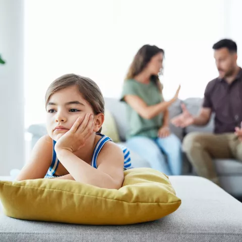 Portrait of a sad child while parents are having an argument at home