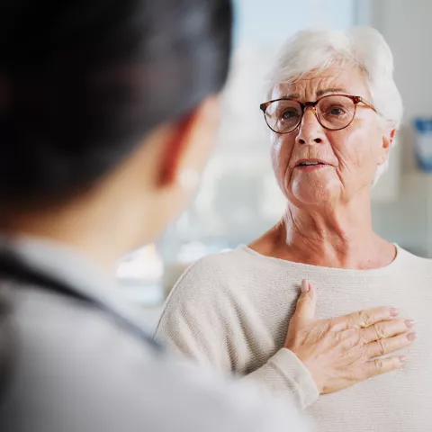 Consulting, chest pain and healthcare with old woman and doctor