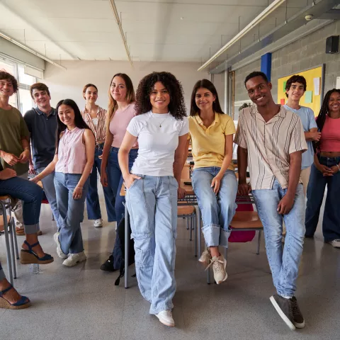 Cheerful group of high school students in classroom
