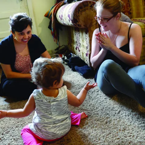 Home visitor working with toddler and mom