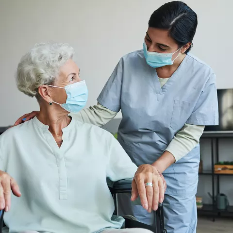 Young Nurse Helping Senior in Wheelchair 