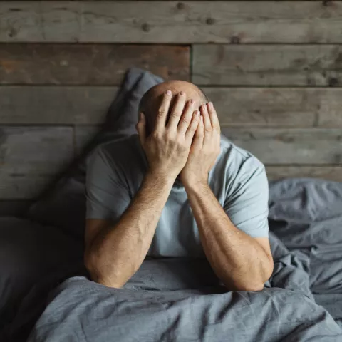 Mature man in bed with headache