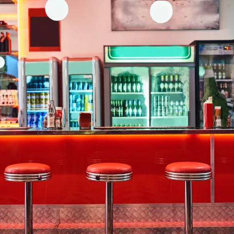 Cropped shot of bar stools in a retro diner