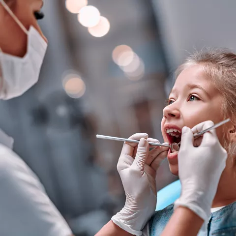 Dental hygienist checking child's teeth.
