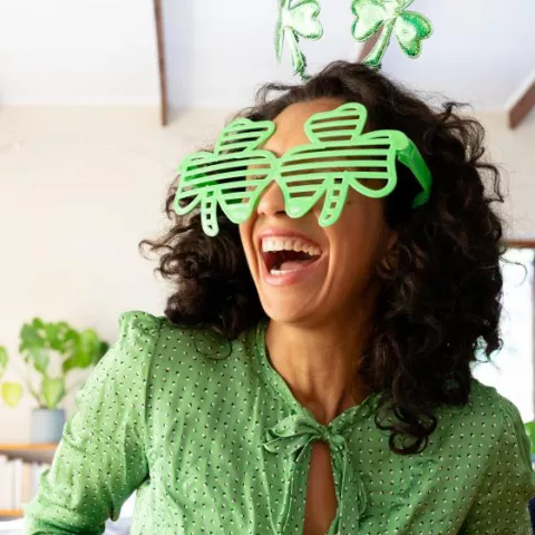 Woman with clover leaf glasses looking excited