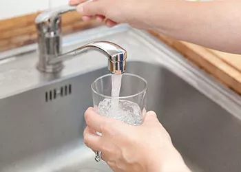 Glass filling with water from tap