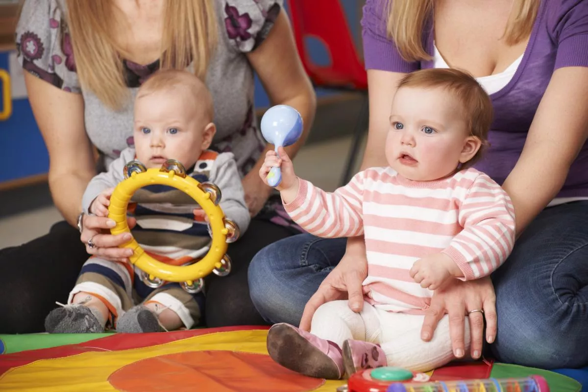 two babies playing with musical instruments