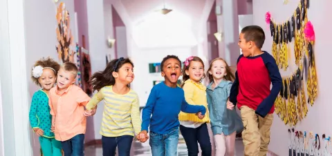 Happy group of children in school hallway