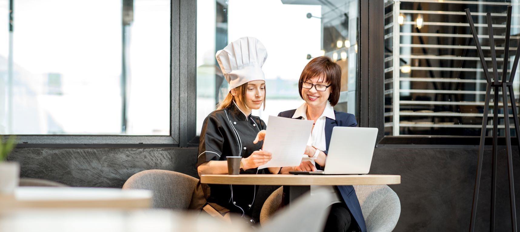 Two restauranteurs reviewing a menu together
