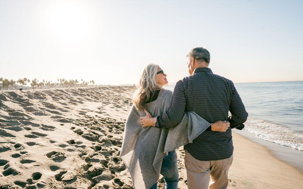 Older couple walking on beach