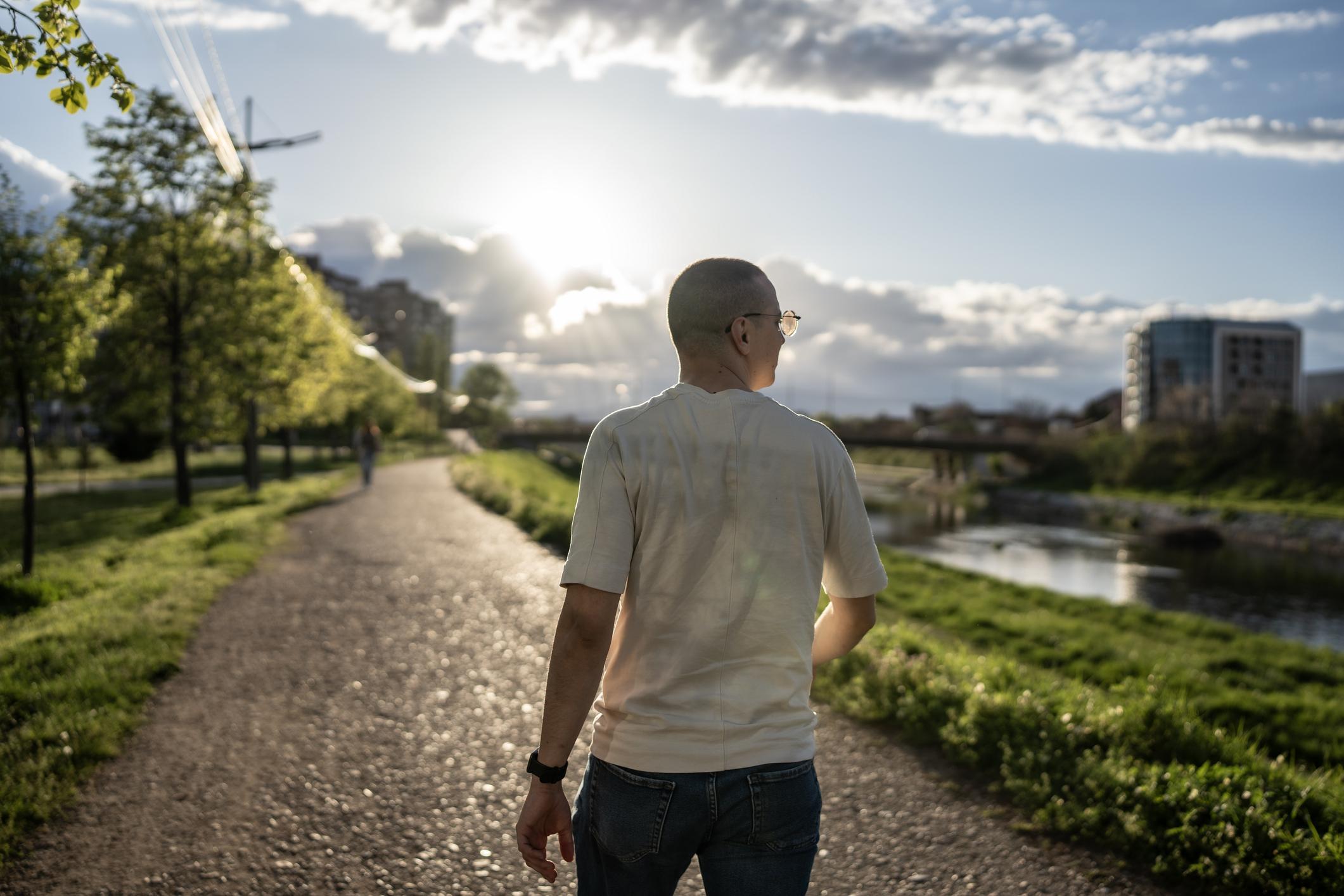Man Walking on a Scenic Path During a Bright Sunny Day 