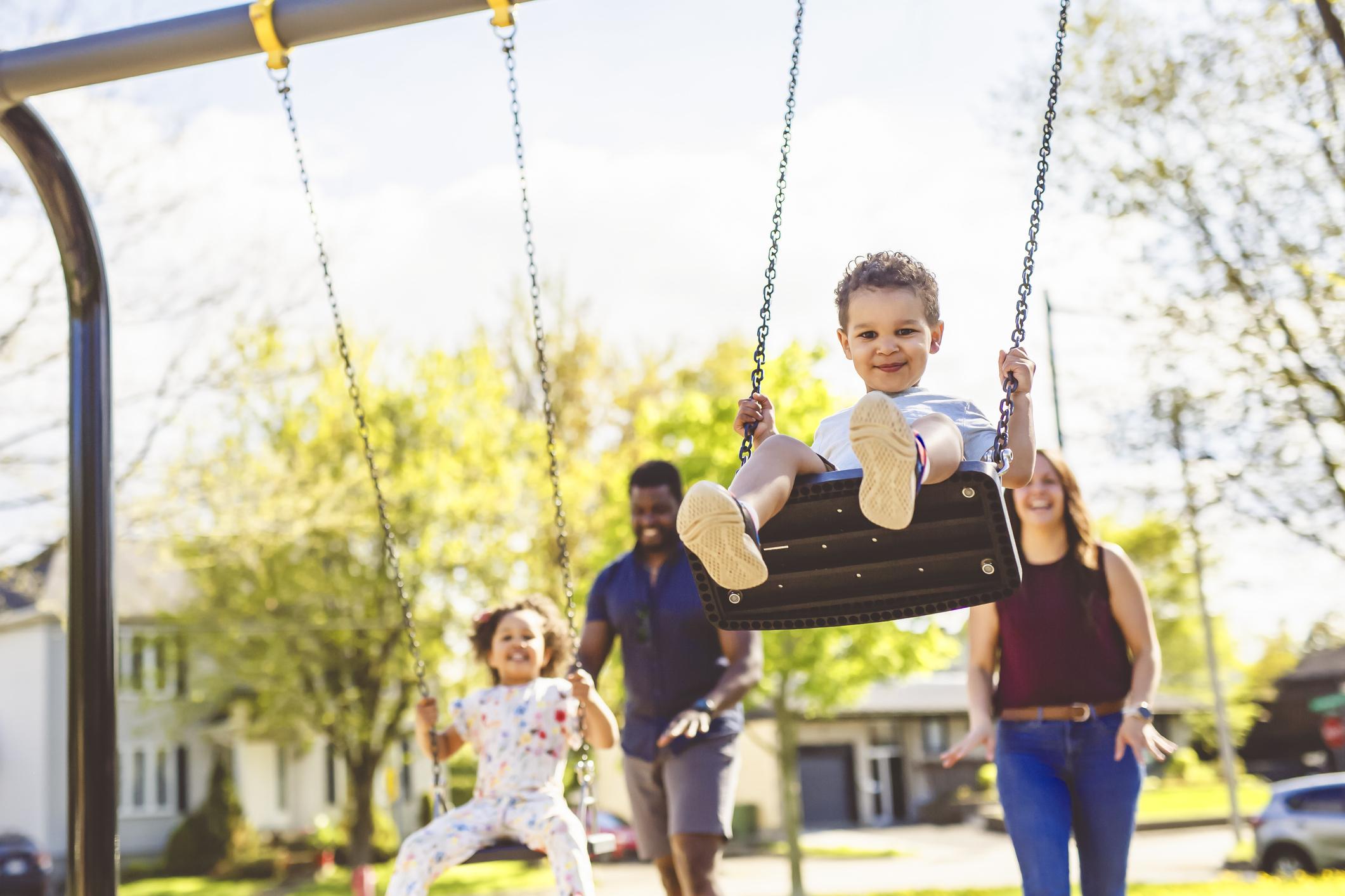 Playtime Moments. family With child Swinging Having Fun on the Playground Outside, 