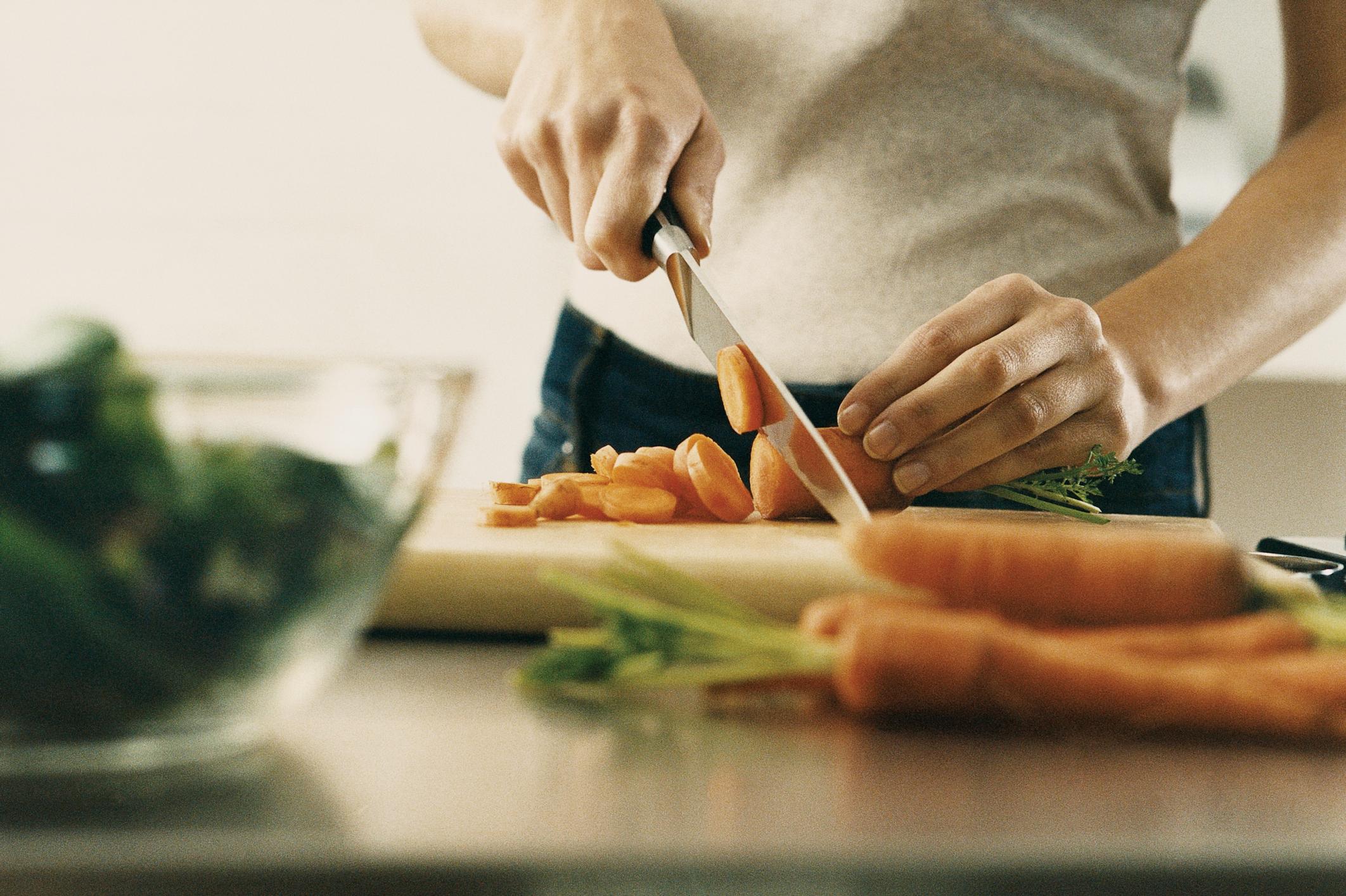 person cutting carrots