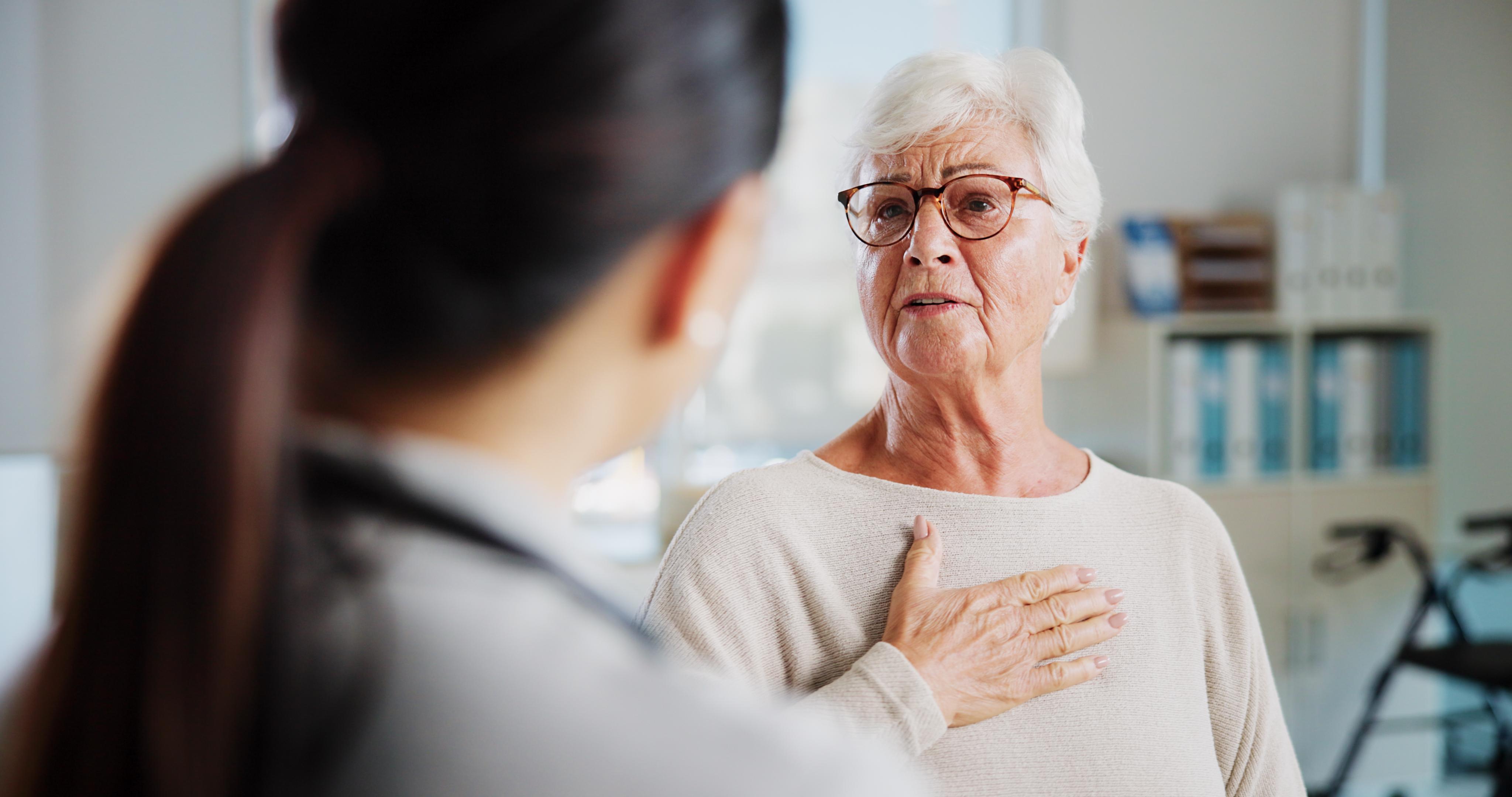 Consulting, chest pain and healthcare with old woman and doctor