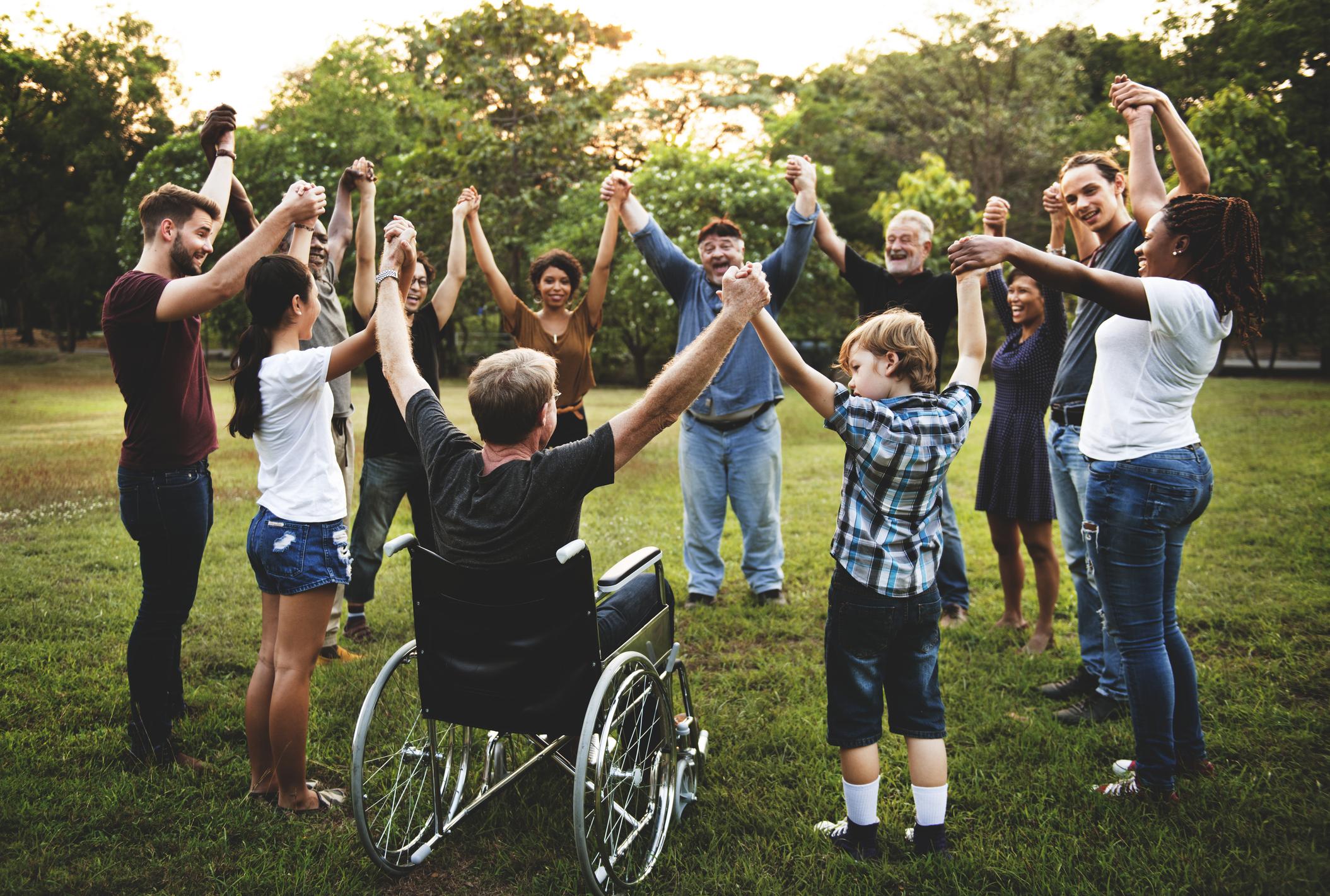 Group of people holding hands in circle outside