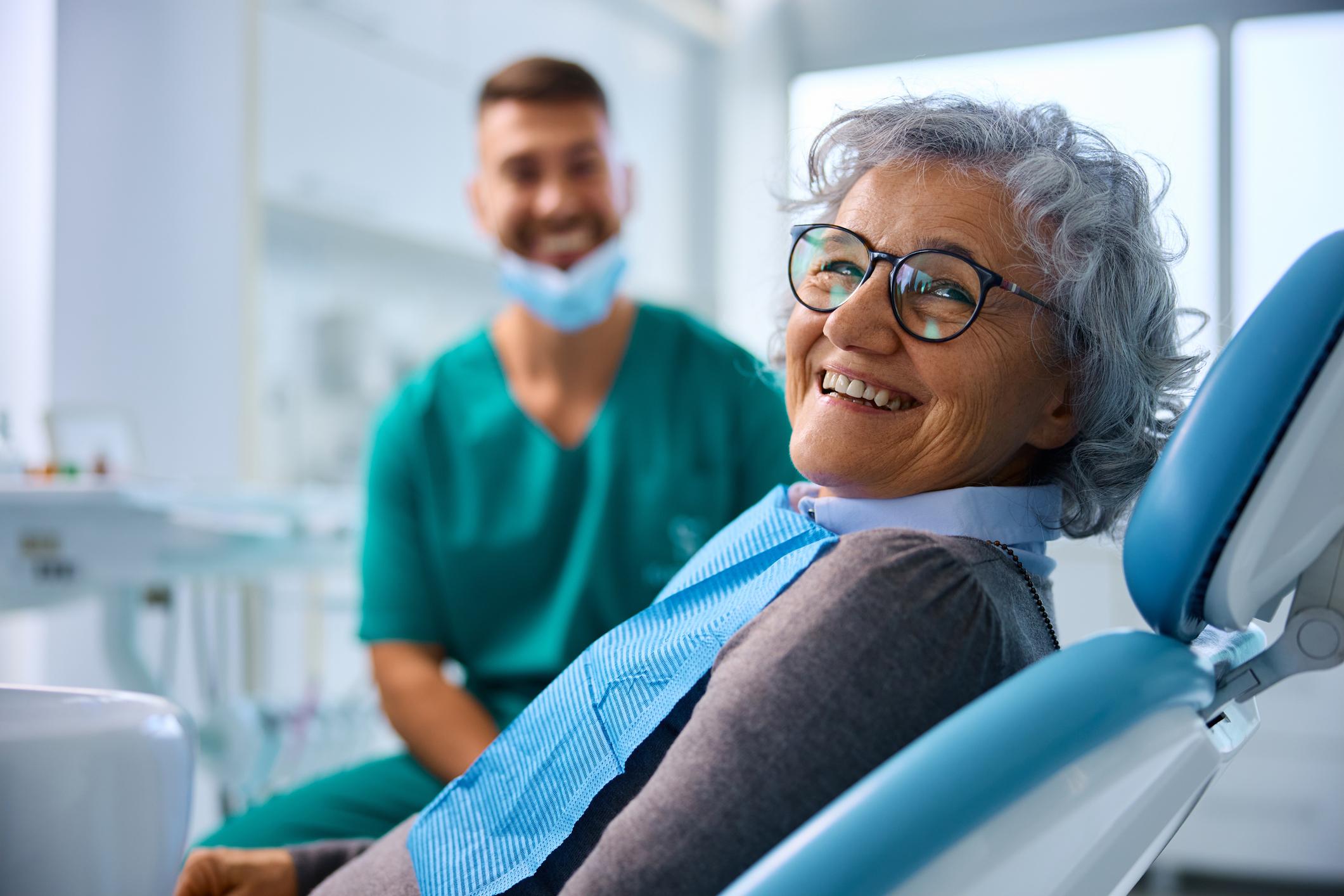 Satisfied senior woman at dentist's office looking at camera. 