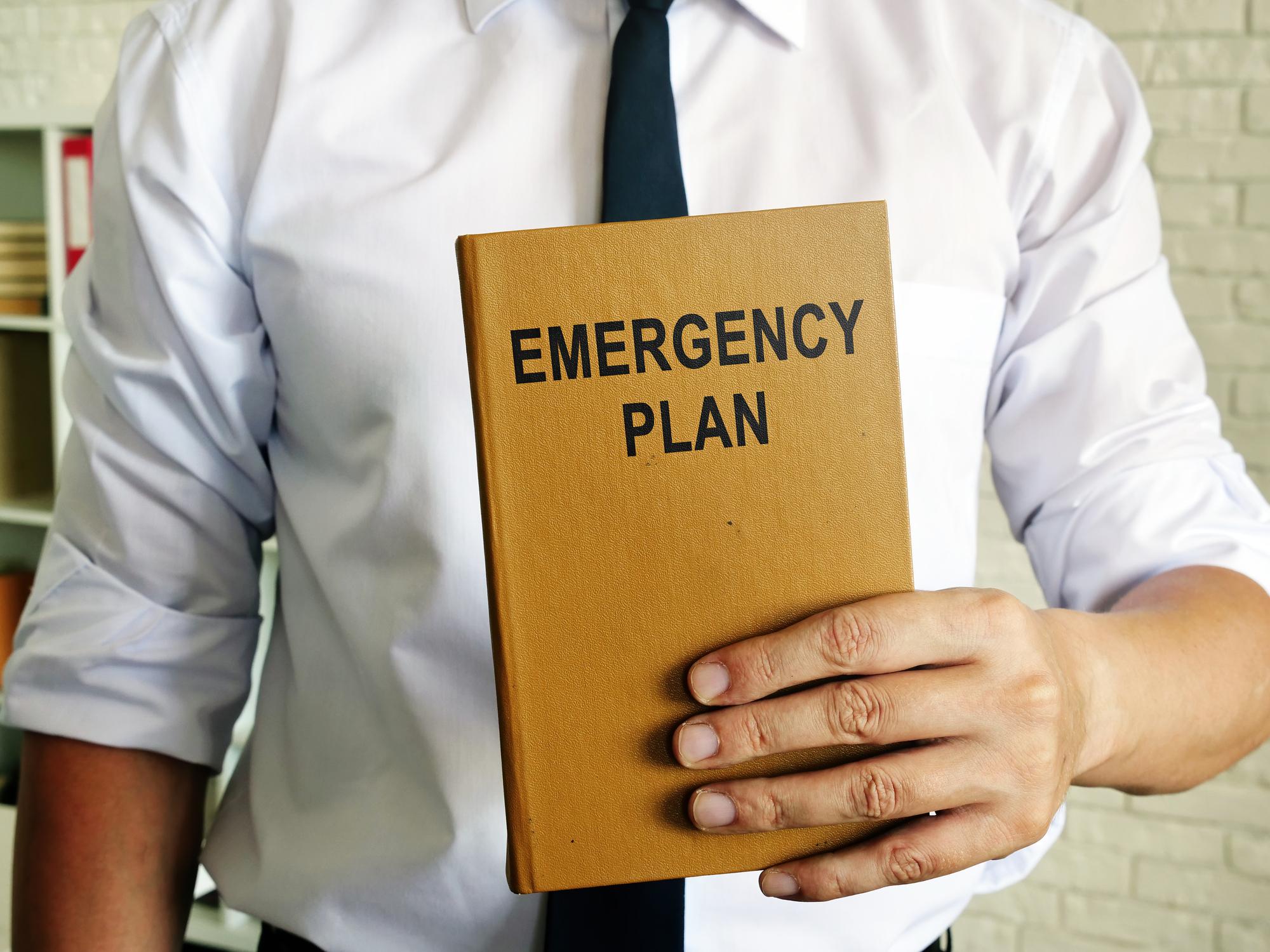 Man holding an emergency response plan for business.
