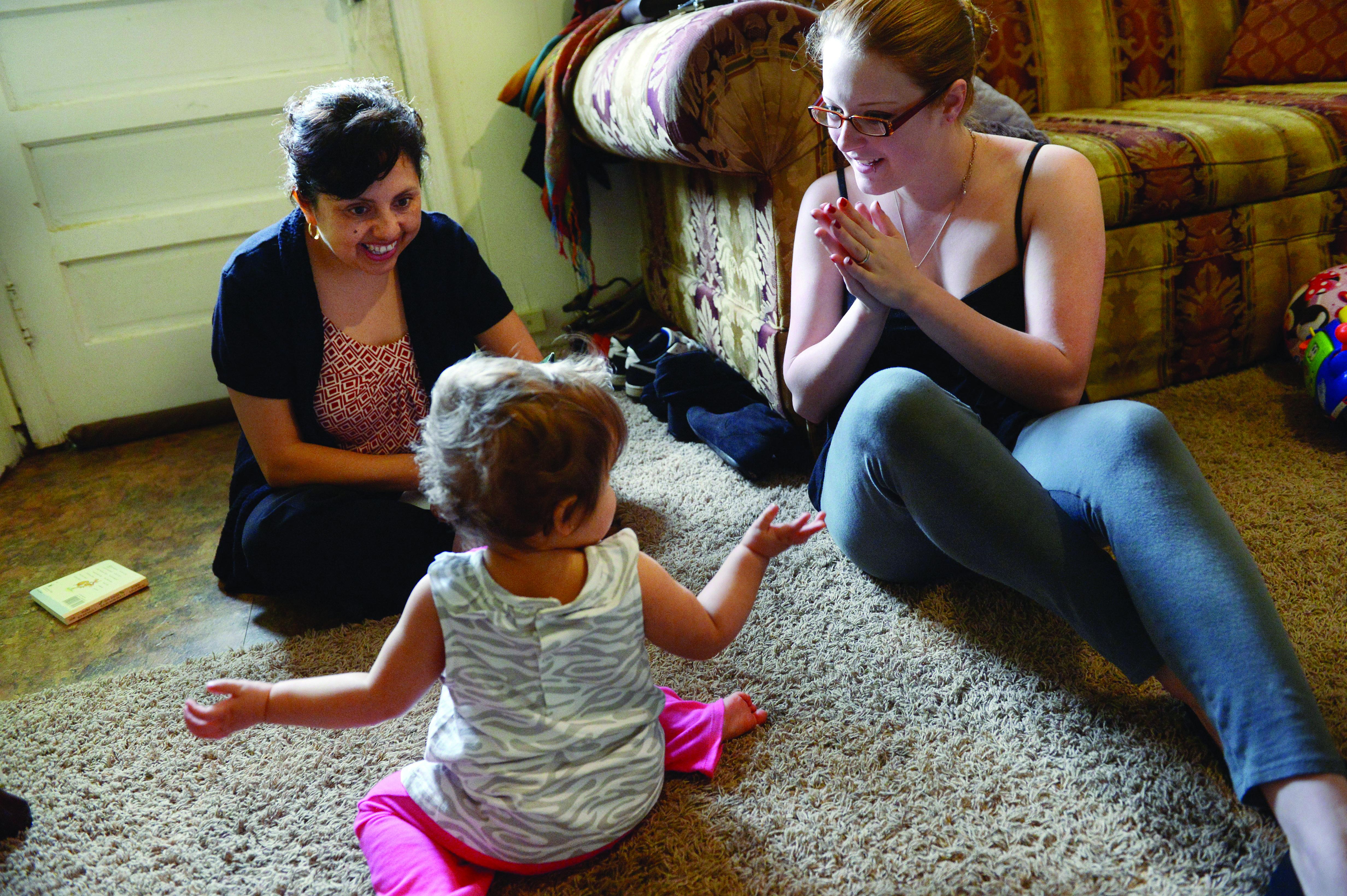 Home visitor working with toddler and mom