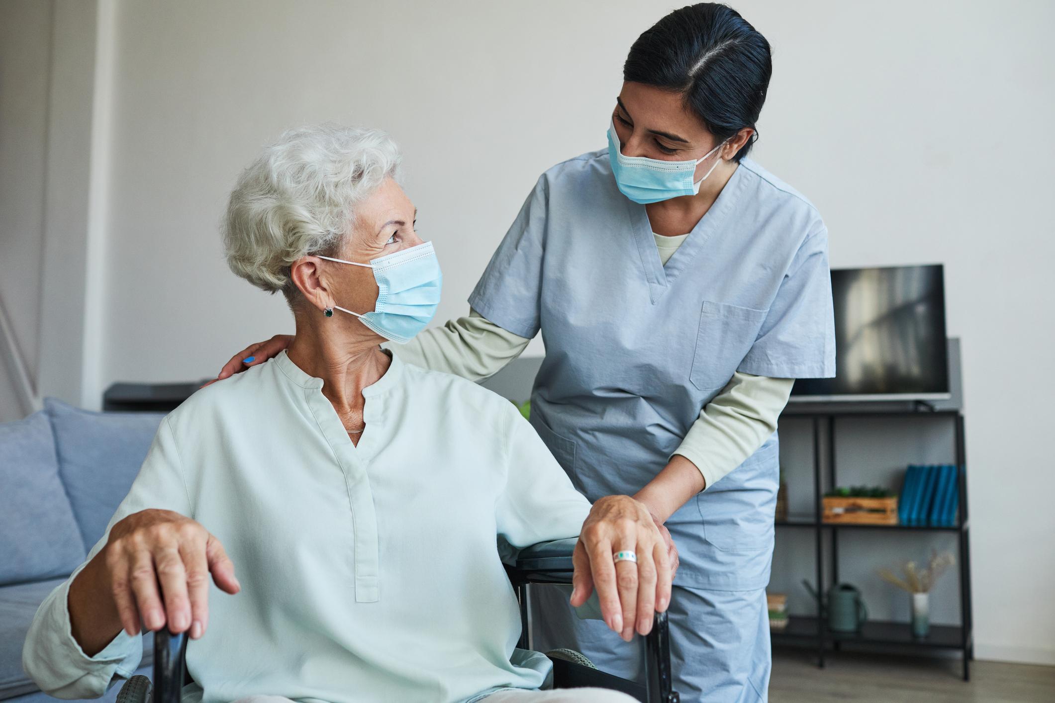 Young Nurse Helping Senior in Wheelchair 