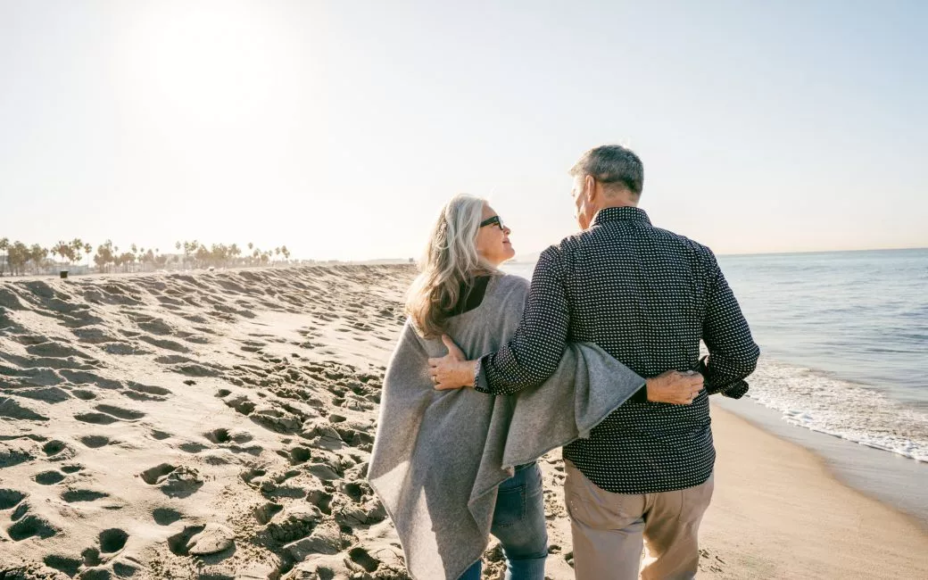 Older couple walking on beach