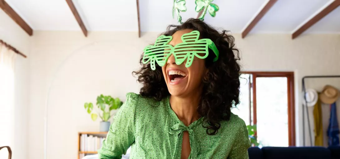 Woman with clover leaf glasses looking excited
